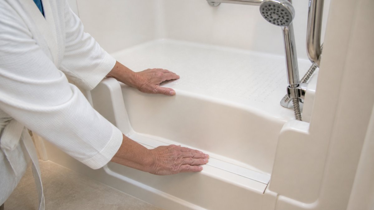 Senior person using a walk-in tub with grab bars to help arthritis pain during their daily bathing routine.